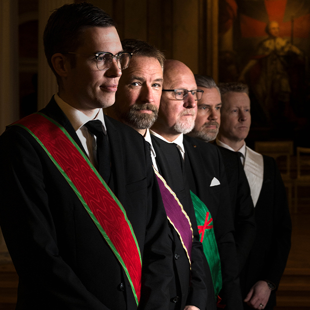 Fem frimurare på led. Mörka kostymer och gradband.